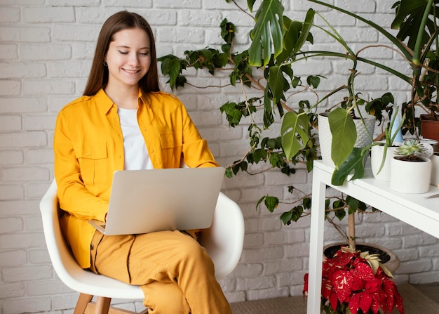 Schöne Gärtnerin, die an ihrem Laptop arbeitet