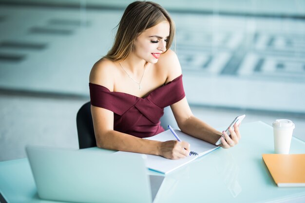 Schöne Geschäftsfrau, die an ihrem Schreibtisch im Büro sitzt