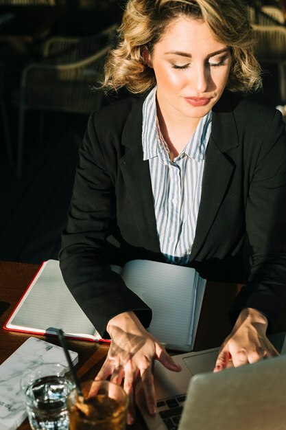 Schöne Geschäftsfrau, die an Laptop im Restaurant arbeitet