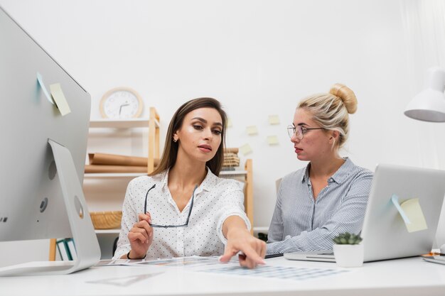 Schöne Geschäftsfrauen, die auf Büro sitzen