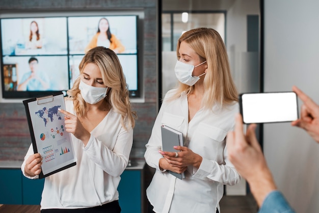 Schöne Geschäftsfrauen, die medizinische Masken tragen