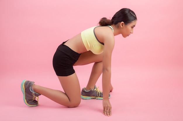 Schöne gesunde junge asiatische Frau, die eine ausdehnende Übung tut, bevor ein Sport gespielt wird.