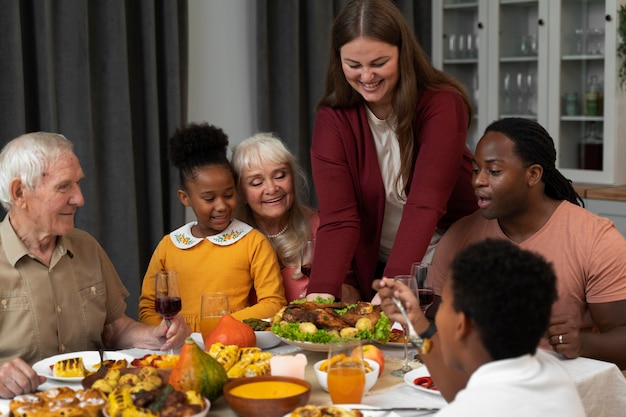 Schöne glückliche Familie, die zusammen ein Thanksgiving-Dinner isst