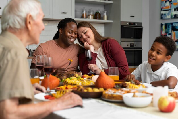 Schöne glückliche Familie, die zusammen ein Thanksgiving-Dinner isst