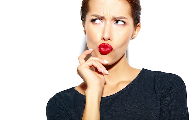 schöne glückliche nette reizvolle Brunettefrau im beiläufigen schwarzen Kleid mit den roten Lippen auf weißer Wand