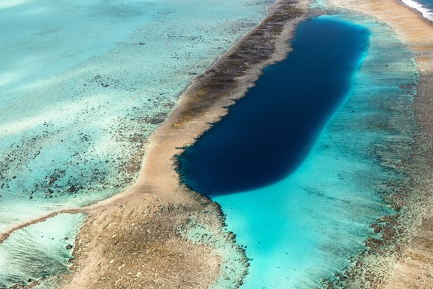 Schöne hohe Winkelaufnahme einer wilden Naturszene des Ozeans gemischt mit dem Sand