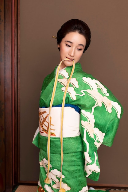 Kostenloses Foto schöne japanische frau, die einen obi anzieht