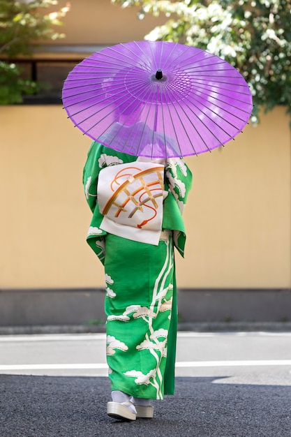 Schöne japanische Frau mit einem lila Regenschirm