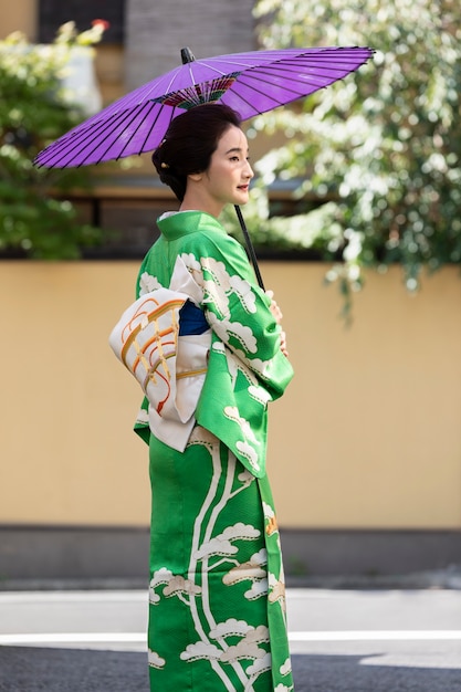 Schöne japanische Frau mit einem lila Regenschirm