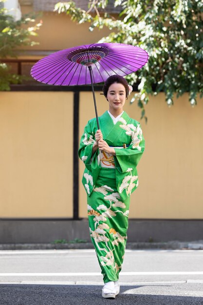 Schöne japanische Frau mit einem lila Regenschirm