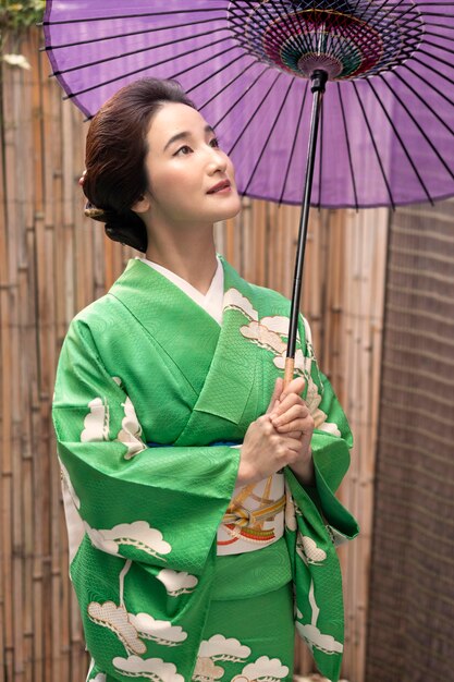 Schöne japanische Frau mit einem lila Regenschirm