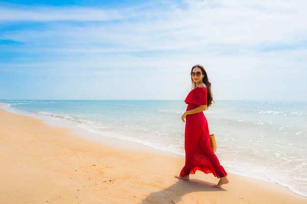 Schöne junge asiatische Frau des Porträts auf dem Strand und dem Meer