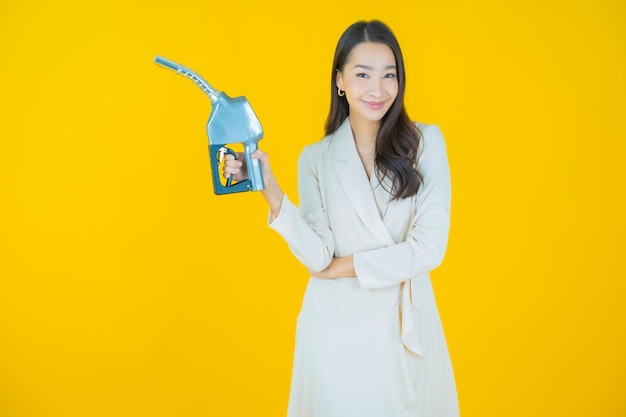 Schöne junge asiatische Frau des Porträts feul Zapfsäule auf Farbhintergrund