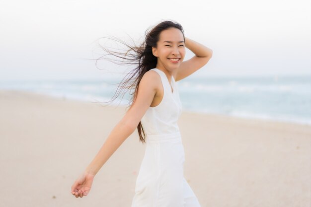 Schöne junge asiatische Frau des Porträts glücklich und Lächeln auf dem Strandmeer und -ozean