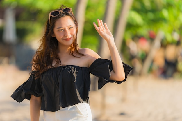 Schöne junge asiatische Frau des Porträts glücklich und Lächeln auf dem Strandmeer und -ozean