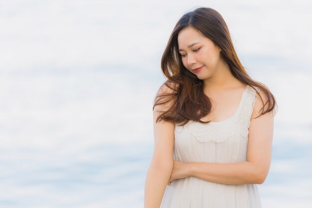 Schöne junge asiatische Frau des Porträts glücklich und Lächeln auf dem Strandmeer und -ozean