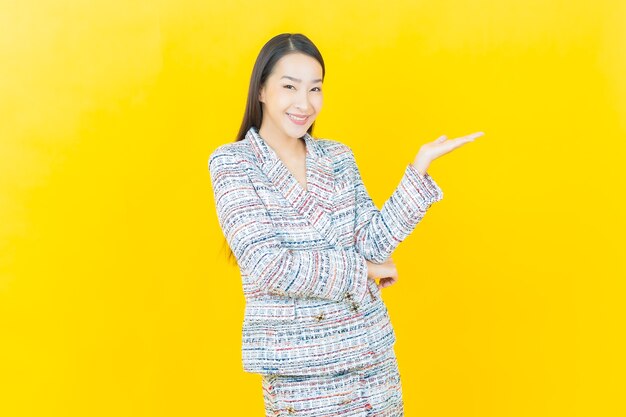 Schöne junge asiatische Frau des Porträts lächelt auf Farbwand