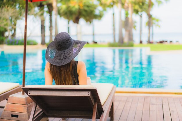 Schöne junge asiatische Frau des Porträts um Swimmingpool