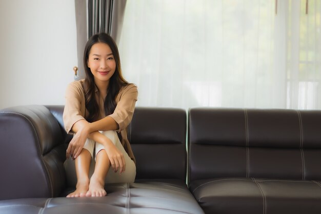 schöne junge asiatische Frau, die auf Sofa entspannt