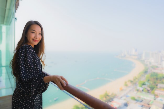 schöne junge asiatische Frau glücklich lächelnd auf Balkon