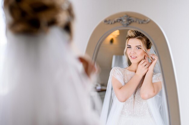 Schöne junge Braut, die sich auf ihren Hochzeitstag vorbereitet