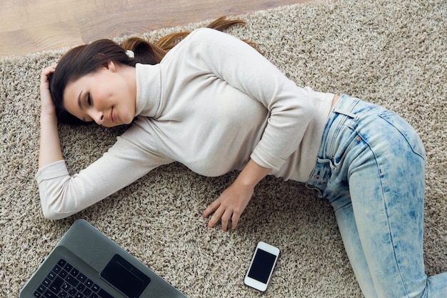 Schöne junge Frau arbeitet an ihrem Laptop zu Hause.