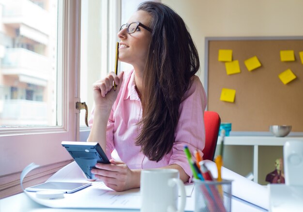 Schöne junge Frau arbeitet in ihrem Büro.