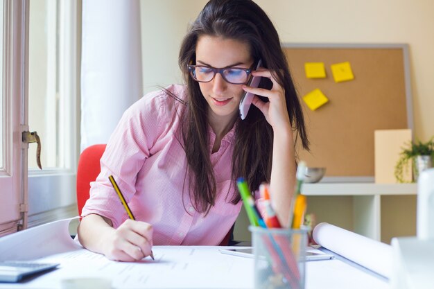 Schöne junge Frau arbeitet in ihrem Büro.