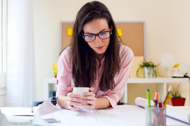 Schöne junge Frau arbeitet in ihrem Büro.