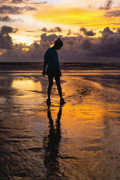 Schöne junge Frau bei Sonnenuntergang auf dem Ozean, Bali, Indonesien.