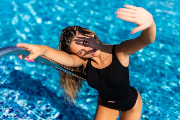 Schöne junge Frau betritt Schwimmbad im Badeanzug