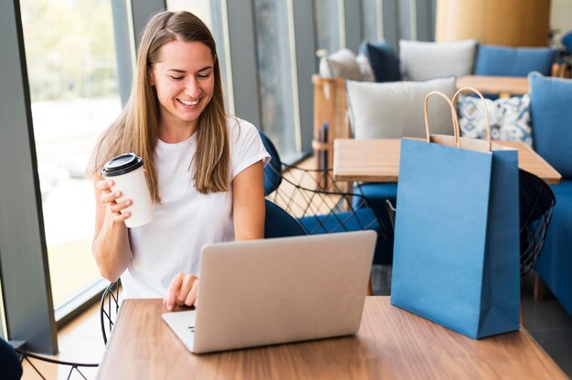 Schöne junge Frau, die am Laptop arbeitet