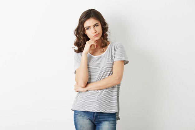 Schöne junge Frau, die an Problem, Hipster-Stil, in Jeans, T-Shirt, lokalisiert auf weißem Hintergrund denkt