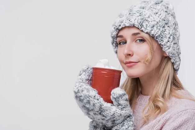 Schöne junge Frau, die Becher hält