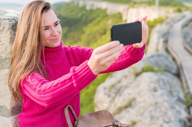 Schöne junge Frau, die ein selfie draußen nimmt