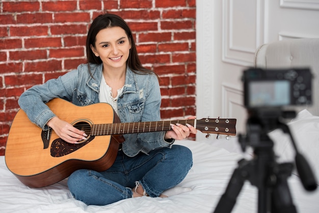 Schöne junge Frau, die Gitarre spielt