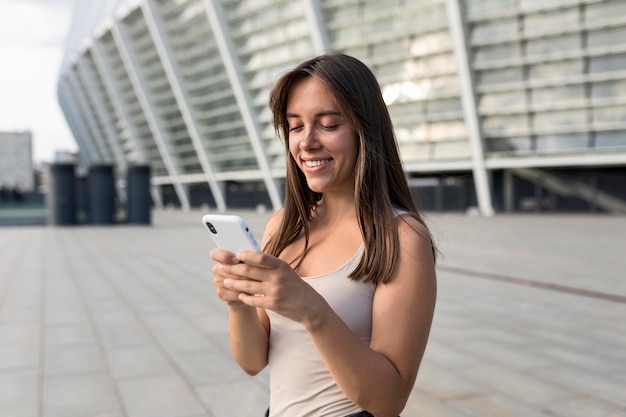 Kostenloses Foto schöne junge frau, die ihr telefon betrachtet