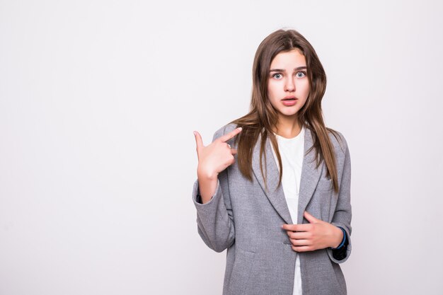 Schöne junge Frau, die ihren Finger lokalisiert auf weißem Hintergrund zeigt