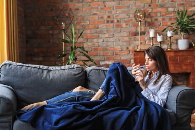 Schöne junge Frau, die im Sofa entspannt