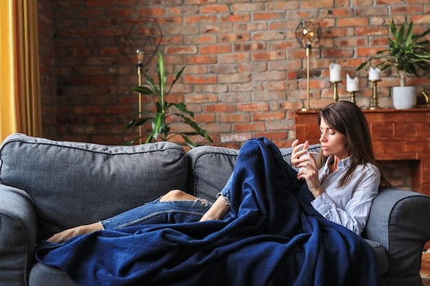 Schöne junge Frau, die im Sofa entspannt