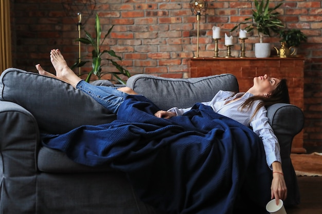 Schöne junge Frau, die im Sofa entspannt