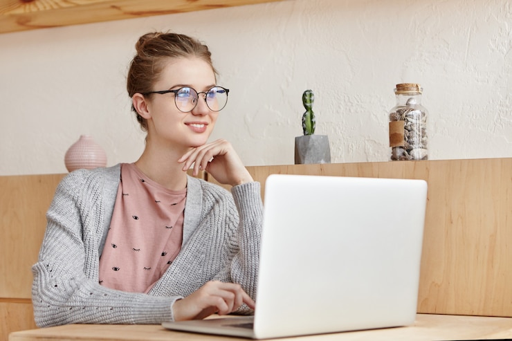 Kostenlose Foto schöne junge frau, die mit laptop arbeitet