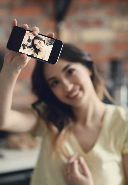 Schöne junge Frau, die selfie mit Smartphone nimmt
