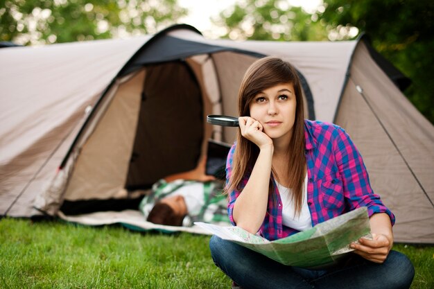 Schöne junge Frau, die vor Zelt sitzt