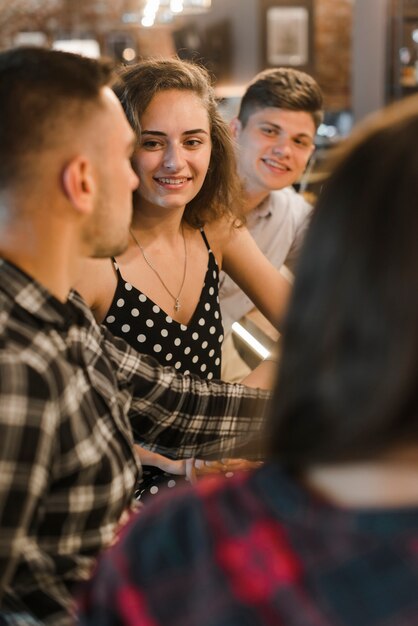 Kostenloses Foto schöne junge frau, die zusammen mit ihren freunden sitzt