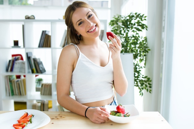 Schöne junge Frau genießen Frühstück zu Hause.