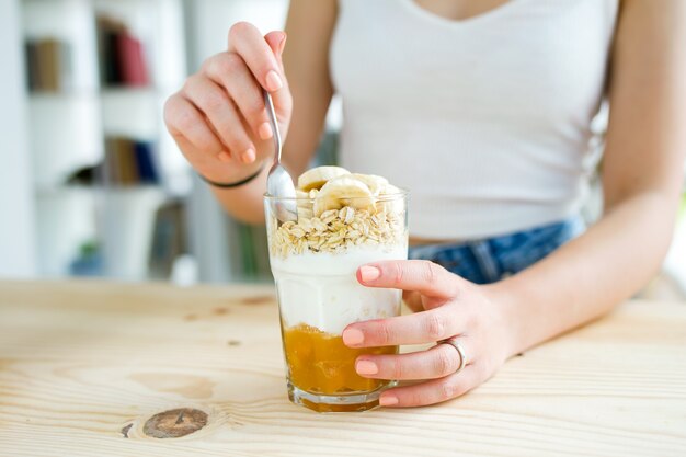 Schöne junge Frau genießen Frühstück zu Hause.