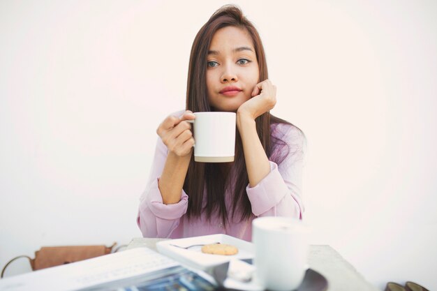 Schöne junge Frau hält eine Tasse