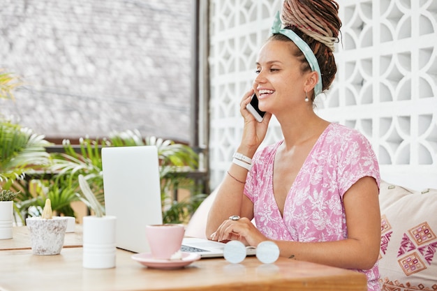 Schöne junge Frau im Kleid im Café