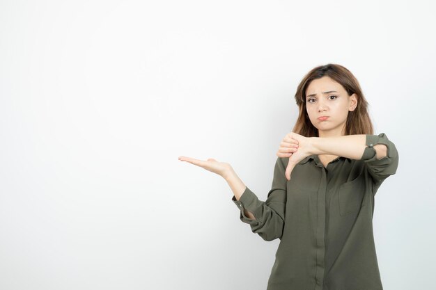 Schöne junge Frau im lässigen Outfit, die ihre geöffneten Handflächen zeigt. Foto in hoher Qualität